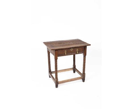 A 17th Century oak side table the planked top above a single drawer on bobbin turned legs united by stretchers, 76cm wide, 55