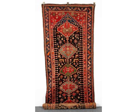 A Karabagh runner South Caucasus, circa 1920, the abrashed indigo field of zoomorphic and ornimorphic motifs centred by a col
