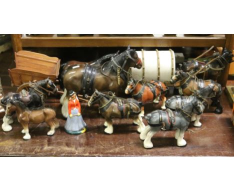 A collection of ceramic models of cart horses along with wooden carts.