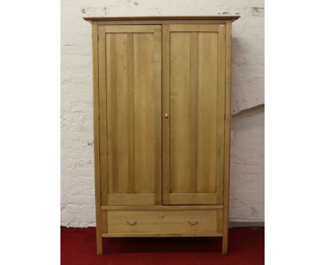 A large panelled beech two door wardrobe with base drawer. 
