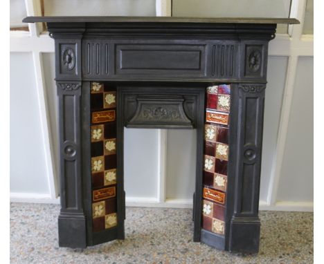 An ornate Victorian cast iron fire surround set with twelve antique tiles.