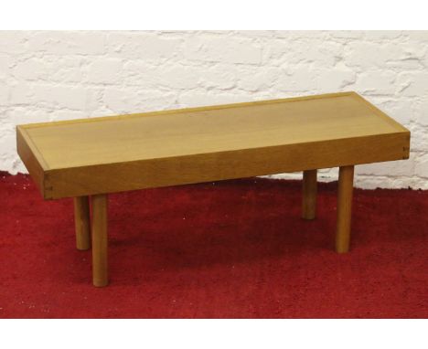 A light oak coffee table raised on turned supports.