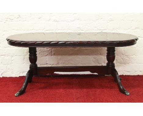 A mahogany twin pedestal oval coffee table by maker John E. Coyle.