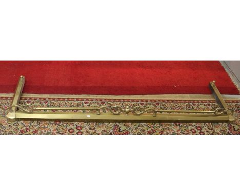 A Victorian brass extending fire fender with scroll and floral top rail either side of central finial. 