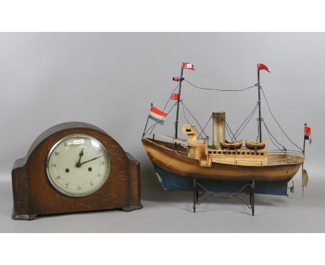 An oak cased Enfield mantel clock chiming on a gong along with a tin plate model of a boat.