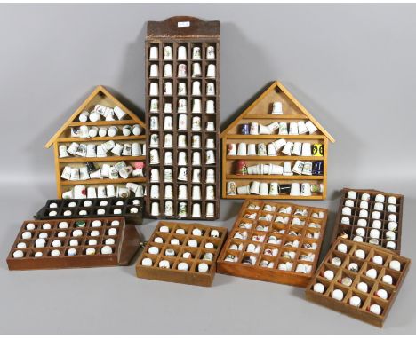 A good collection of ceramic thimbles all on wooden display racks.