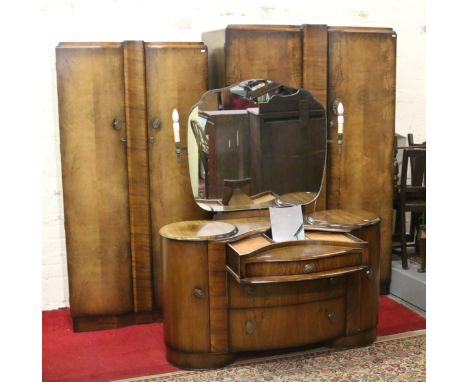 A 1930s walnut three part bedroom suite comprising double wardrobe, gents fitted robe and dressing table with sliding make-up