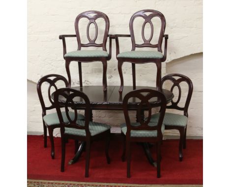 A carved mahogany twin pedestal extending dining table, along with four plus two carver dining chairs.