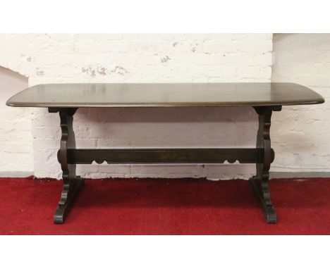 A large dark oak Ercol refectory dining table.