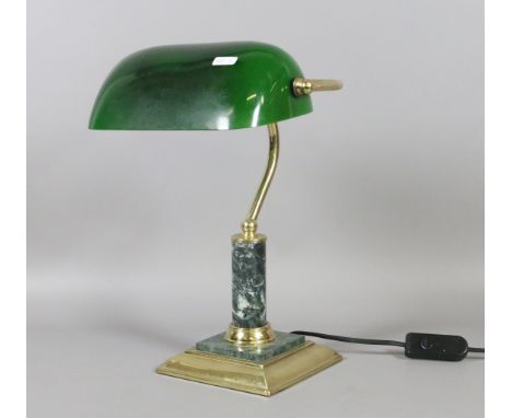 A brass based reading lamp with green glass shade.