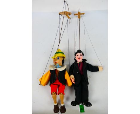 Unbranded - 2 x vintage marionettes, Charlie Chaplin and Pinocchio. Charlie is 28 cm tall, Pinocchio is 30 cm tall. They show