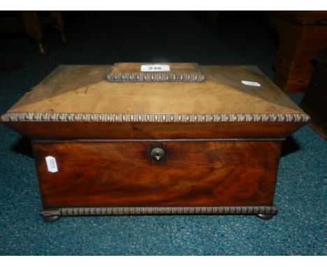 An early Victorian mahogany sarcophagus shape tea caddy on bun feet