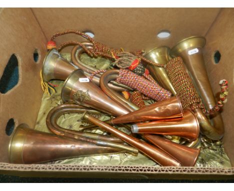 A group of bugles, some with assorted military badges, along with a number of hunting horns