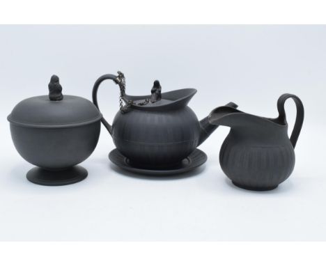 A collection of early 19th century Wedgwood black basalt comprising a globular teapot and cover, a jug and a pedestal sugar b