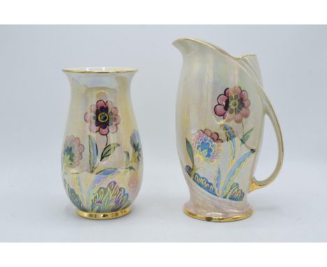 A trio of Royal Winton Grimwades items with a floral design on light coloured background to include a jug, vase and two-handl