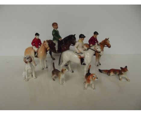 Four ceramic huntsman on horseback, three hounds and one fox, largest 18cm 