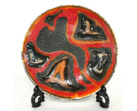 A Poole Pottery Studio dish in an Abstract design in early textured glazes by Margaret Anderson (8 inches diameter).