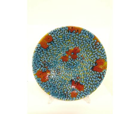 A Poole Pottery Studio charger.  A one off design by Janice Tchalenko of stylised flowing blue water droplets with scarlet hi