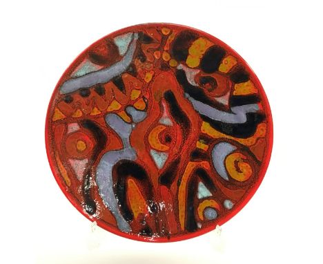 A Poole Pottery Delphis dish, bold abstract design in early glazes, decorated by Irene Kerton, shape 5 (14 inches diameter).