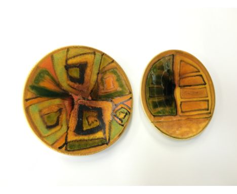 A Poole Pottery Studio pin dish, shape 49, decorated in early glazes in an Abstract design (5 inches diameter) together with 