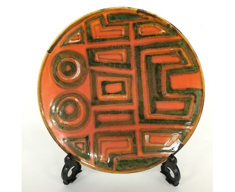 A Poole Pottery Studio dish in an Abstract design in early textured glazes (8 inches diameter).