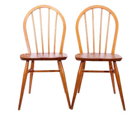 Two mid-20th century blonde wood Ercol chairs with spindle back supports and tapering legs, 86cm high