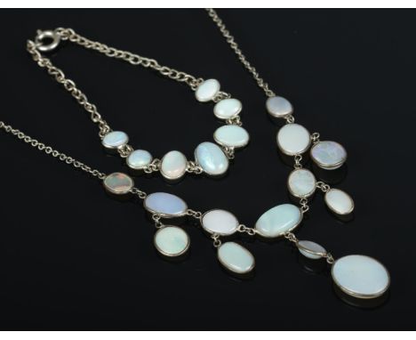 A white metal jewellery suite containing necklace and bracelet featuring oval opal plaques.  Necklace requires new clasp.