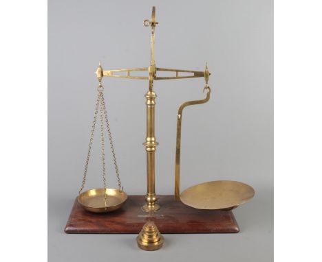 A set of brass balance scales on mahogany base. With weights, some stamped for WH West, Norwich.