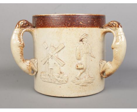 A large 19th century stoneware tyg. With moulded dog handles and relief hunting/farming scenes. Height 18cm.