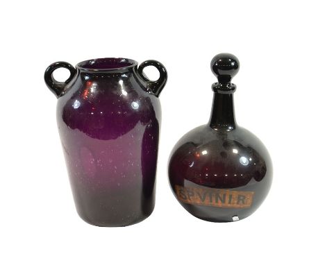 An early 19th Century apothecary carboy of bulbous form in deep amethyst glass and ground stopper, labelled in black on gilt 