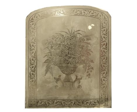 A Victorian arch form glass panel with etched decoration depicting a flower filled classical urn within foliate scroll border