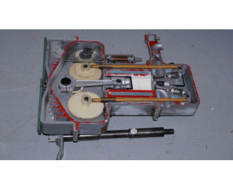 A Hand-operated Cut-away Model 4-stroke Petrol Engine, made of plastic and wood and measuring approx. 25" high, with operatin
