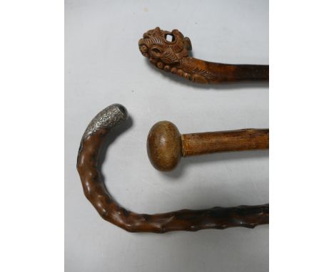 Three Carved Walking Sticks: including oriental inspired item, silver banded item etc (3):