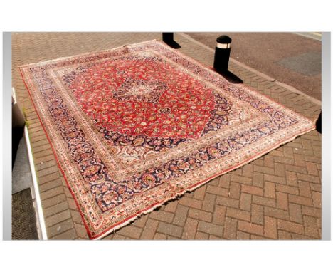 A Large Persian Carpet In The Meshad Style, with a central floral motif with corresponding blue border. Slightly worn. 158x11