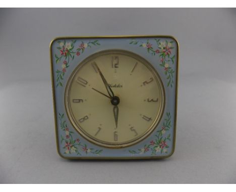 Small Dressing Table Clock by Westlok, Scotland. Ceramic floral border and round cream face with Arabic Numerals. 4 inches in