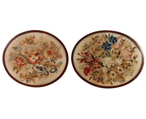 A PAIR OF 19th CENTURY OVAL FLORAL TAPESTRY PICTURES 24cm high 36cm wide - in glazed cross banded mahogany frames
