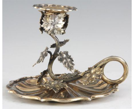 A WILLIAM IV SILVER GILT CHAMBER STICK the scallop edged segmented base with vine work stem and scroll handle; with matching 