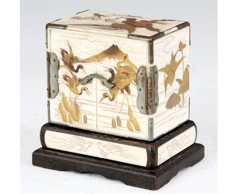 A LATE 19TH CENTURY JAPANESE IVORY AND CHINOISERIE MINIATURE TABLE CABINET with metal corner mounts and lacquer stand decorat