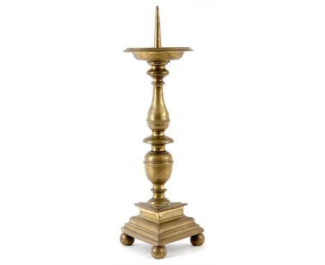 AN 18TH CENTURY CONTINENTAL LARGE CAST BRASS PRICKET CANDLESTICK with broad dished drip pan ringed knopped stems and triangul