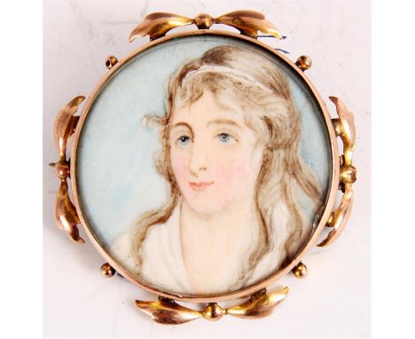 A VICTORIAN CIRCULAR MINIATURE BUST PORTRAIT ON IVORY OF A YOUNG LADY in leaf work gold metal frame 4.5cm diameter