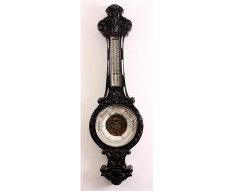 A MASSIVE VICTORIAN CARVED OAK ANEROID WHEEL BAROMETER/THERMOMETER with calibrated pottery dials and dished centre to the bar