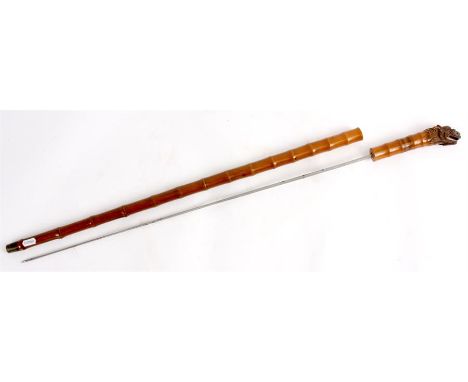A LATE 19TH/EARLY 20TH CETURY CHINESE BAMBOO SWORD STICK with triangular steel tapering blade and carved dragons head handle 