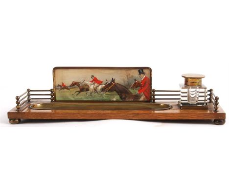 EARLY 20TH CENTURY OAK AND BRASS INK STAND having glass inkwell with beveled edges and hinged brass lid, brass pen tray and g