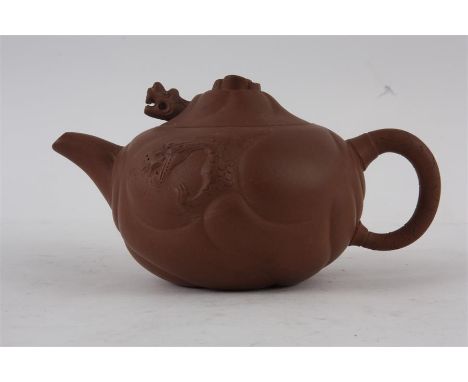 A 19TH CENTURY CHINESE TERRACOTA TEAPOT the moulded panelled body with dragons head handle to the lid 10.5cm high