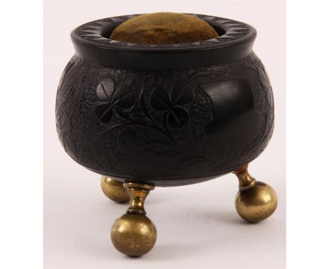 OF IRISH INTEREST  A 19TH CENTURY CARVED BOG OAK PIN CUSHION the turned body carved with clovers, harp, castle and a seated h