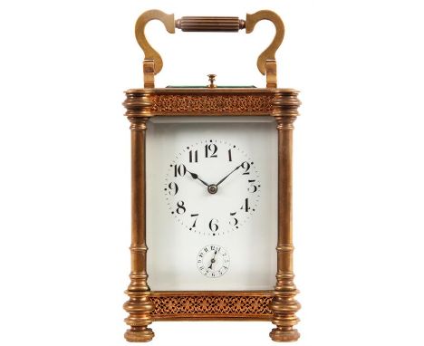 A LATE 19TH CENTURY GILT BRASS REPEATING CARRIAGE CLOCK  with partly reeded shaped folding handle, outset corner columns and 