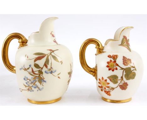 TWO GRADUATED LARGE ROYAL WORCESTER IVORY GROUND GILT EDGED FLATBACK JUGS with gilded celery type handles decorated colourful