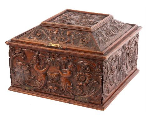 A 19TH CENTURY CONTINENTAL CARVED OAK TABLE CABINET the angled top with lift up compartment above a fold down locked front en