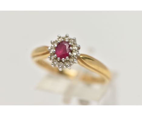 AN 18CT GOLD, RUBY AND DIAMOND CLUSTER RING, designed with an oval cut ruby, in a twelve claw setting, in a surround of twelv