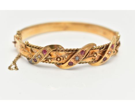 AN EARLY 20TH CENTURY GOLD BANGLE, a hinged bangle designed with foliage and wire work detail, set with three rose cut diamon